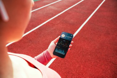 Sağlık uygulaması. Spor salonu ya da spor salonu mobil uygulaması olan akıllı telefon ekranı. Evde tutulan kadın çevrimiçi egzersiz uygulaması