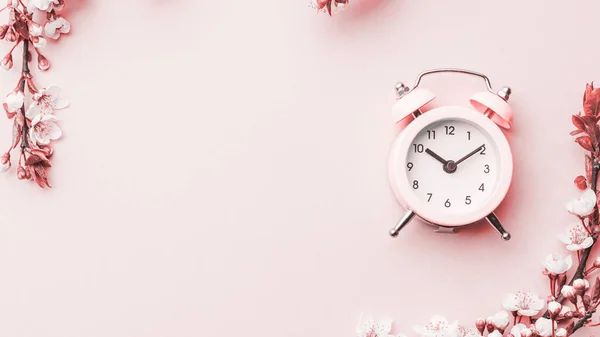 春の時間花を咲かせ ピンクの目覚まし時計で花を咲かせます バナーのために 背景に桜の花の枝 夢のようなロマンチックなイメージ 風景パノラマ コピースペース — ストック写真