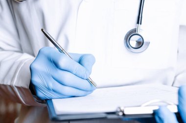 Doktor dosyasının tıbbi geçmişi. Mavi eldivenli mutlu hemşire, hastane üniformalı hasta dosyasını beyaza sarılı tutuyor. Sağlık hizmetleri ve sağlık hizmetleri afişi