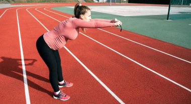 Hamilelik yoga egzersizi. Hamile kadın yoga sporu antrenmanı yapıyor. Dışarıda doğum öncesi sağlıklı spor salonu var. Hamilelik sağlığı