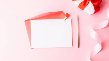 Anneler günü dairesi. Bahar beyazı lale çiçeği, pembe arka planda kırmızı kurdeleli hediye. Sevgililer Günü, Kadınlar Günü tebrik kartı