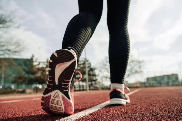 Spor koşusu kadın eğitimi. Koşu kız egzersizi. Koşan ayaklar yolda, ayakkabıya yakın gidiyor. Fitness, spor, yaşam tarzı konsepti