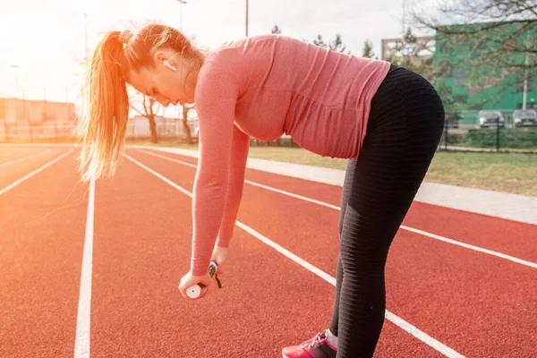 Hamilelik egzersizi. Hamile kadın yoga sporu antrenmanı yapıyor. Dışarıda doğum öncesi sağlıklı spor salonu var. Hamilelik koşusu