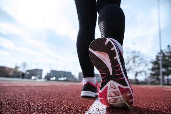 Spor koşucusu kadın egzersizi. Koşan ayaklar yolda, ayakkabıya yakın gidiyor. Kadın egzersizi yap. Spor ve sağlıklı yaşam tarzı