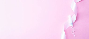 Adet öncesi tampon, kadın hijyeni. Pembe arka planda adet tamponu olan pembe kurdele. Adet dönemi kadınsı. Hijyen konsepti. Sağlık sigortası jinekolojik afişi