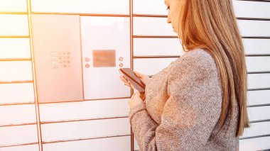 Posta dolabı. Otomat terminali ve paket kurye kutusuyla birlikte eller. Paket teslimatı, dolap teslimatı, paket teslimatı, paket teslimatı.