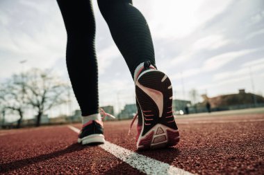 Spor koşucusu kadın egzersizi. Koşan ayaklar yolda, ayakkabıya yakın gidiyor. Kadın egzersizi yap. Spor ve sağlıklı yaşam tarzı