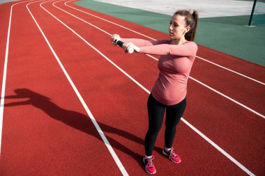 Hamilelik eğitimi. Hamile kadın yoga sporu antrenmanı yapıyor. Dışarıda doğum öncesi sağlıklı spor salonu var. Doğum öncesi egzersizleri.
