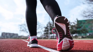 Spor koşusu kadın eğitimi. Koşu kız egzersizi. Koşan ayaklar yolda, ayakkabıya yakın gidiyor. Fitness, spor, yaşam tarzı konsepti