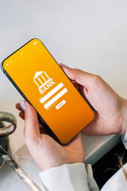 Mobil bankacılık. İnternet banka uygulamalı akıllı telefonu olan bir kadın. Banka kartı cüzdanı uygulaması. Para tasarrufu iş kavramı