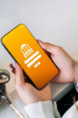 Mobil bankacılık. İnternet banka uygulamalı akıllı telefonu olan bir kadın. Banka kartı cüzdanı uygulaması. Para tasarrufu iş kavramı