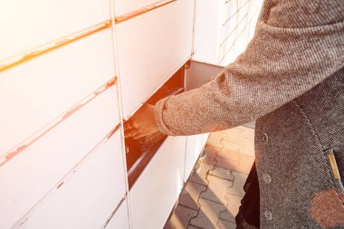 Posta dolabı. Otomat terminali ve paket kurye kutusuyla birlikte eller. Paket teslimatı, dolap teslimatı, paket teslimatı, paket teslimatı.