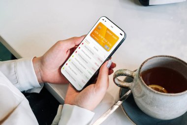 Mobil bankacılık uygulaması. İnternet banka uygulamalı cep telefonu olan bir kız. Kredi kartı cüzdanı başvurusu. Para biriktir iş cüzdanı