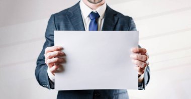 İşadamı boş kartı. Beyaz, boş bir şablon beyaz arka planda iş adamı tutuyor. Boşluk posterini kopyala.