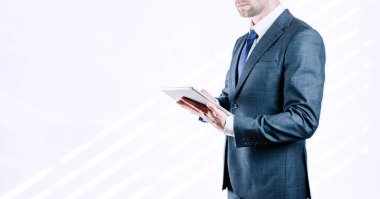 Tablet kullanan bir iş adamı. Ekonomik büyüme grafikleri ve veri satışlarını analiz eden genç bir iş adamı. Dijital pazarlama teknolojisi afişi.