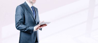 Tablet kullanan bir iş adamı. Ekonomik büyüme grafikleri ve veri satışlarını analiz eden genç bir iş adamı. Dijital pazarlama teknolojisi afişi