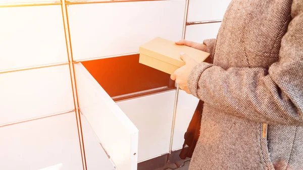 Post locker. Delivery automat terminal and hands with parcel courier box. Parcel delivery, pickup point with lockers, hand with parcel, contactless pack delivery