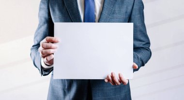 İşadamı boş kartı. Beyaz, boş bir şablon beyaz arka planda iş adamı tutuyor. Boşluk posterini kopyala