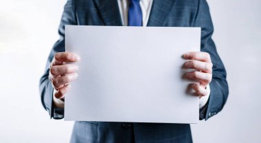 Boş kart şablonu. İşadamı beyaz arka planda boş bir şablon tutuyor. Boş mukavva