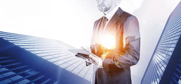 Businessman using tablet double exposure. Young business man analyzing economic growth graph chart and data sales. Digital marketing technology banner