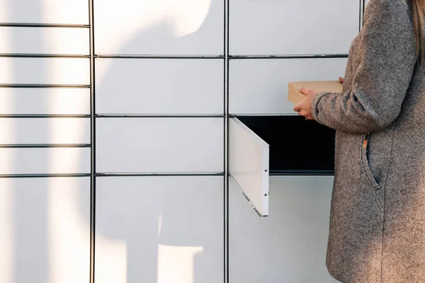 Post locker. Delivery automat terminal and hands with parcel courier box. Parcel delivery, pickup point with lockers, hand with parcel, contactless pack delivery