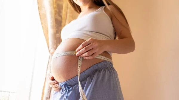 妊娠中の腹の女性の測定 腹を測定するテープで幸せな美しい妊婦 医学ヘルスケアの概念 — ストック写真