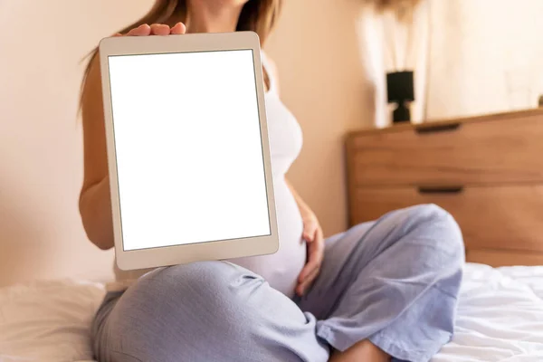 Pregnancy digital tablet screen. Pregnant woman holding smart tablet mock up. Mobile pregnancy online maternity application. Concept of pregnancy, maternity, expectation for baby birth