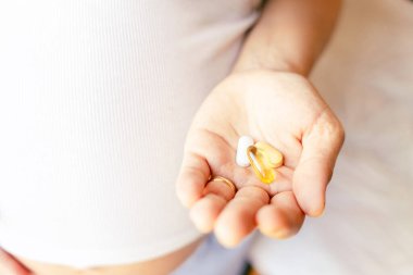 Annelik takviyesi hapı. Mutlu gülümseyen kadın Omega 3 vitamini ile hap alıyor. Hamilelik, ilaç sağlık konsepti