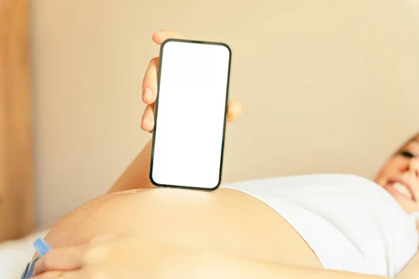 怀孕模仿智能手机 拿着智能手机的孕妇模拟了流动怀孕的网上孕产申请 概念孕产 — 图库照片