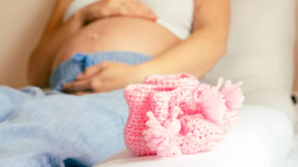 赤ちゃんの靴妊娠中の女性 ピンクの赤ん坊の靴を保持する美しい妊婦 出産への期待 — ストック写真