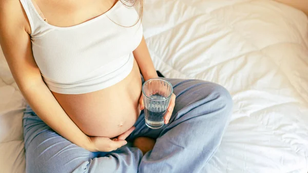 怀孕饮水的女人 年轻的怀孕母亲喝水 怀孕的女人在等孩子 一杯水 期望的概念 — 图库照片