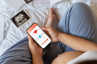 Hamilelik takvimi uygulaması. Taşınabilir hamilelik çevrimiçi annelik başvurusu. Hamile anne telefon kullanıyor. Hamilelik kavramı, annelik, bebek doğumu beklentisi