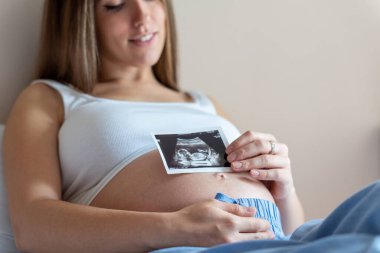 Ultrason fotoğrafı hamile bebek fotoğrafı. Ultrason görüntüsü taşıyan bir kadın. Hamilelik kavramı, annelik, bebek doğumu beklentisi