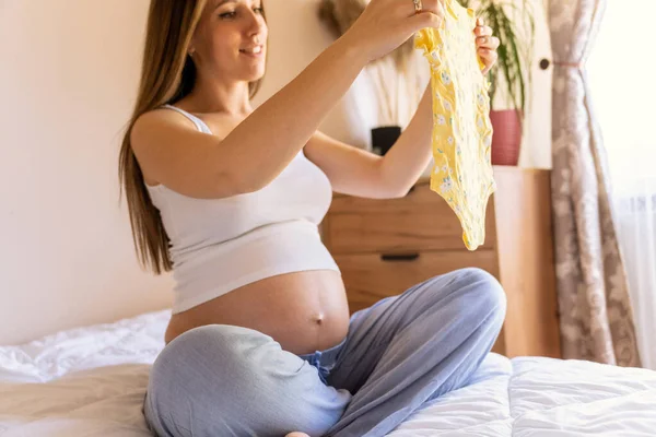 Ropa Bebé Mujer Feliz Embarazo Joven Madre Sosteniendo Ropa Bebé — Foto de Stock