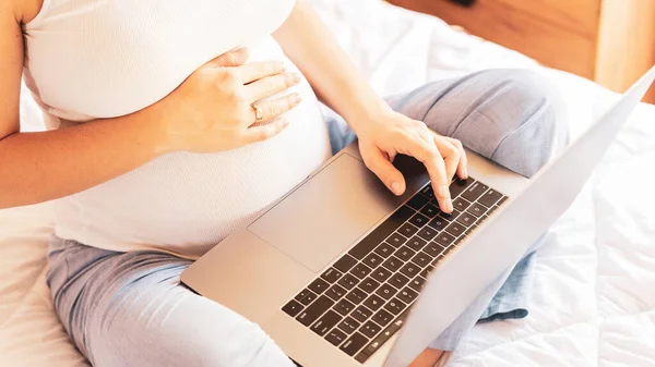 Pregnancy app laptop. Mobile pregnancy online maternity notebook application. Pregnant mother using digital computer. Concept of pregnancy, maternity, expectation for baby birth