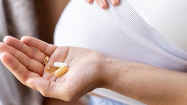 Sağlık, tedavi, takviye malzemeler. Mutlu gülümseyen kadın Omega 3 vitamini ile hap alıyor. Hamilelik, ilaç sağlık konsepti