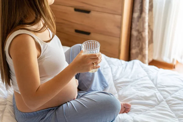 Pregnant drink water. Beautiful pregnancy drinking water. Happy pregnant lady holding glass of water. Pregnancy, maternity, healthcare concept