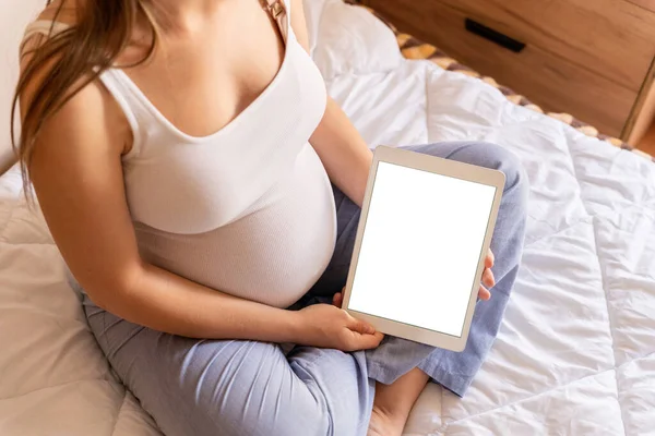 Pregnancy digital tablet mockup. Pregnant woman holding smart tablet. Mobile pregnancy online maternity application mock up. Concept of pregnancy, maternity, expectation for baby birth