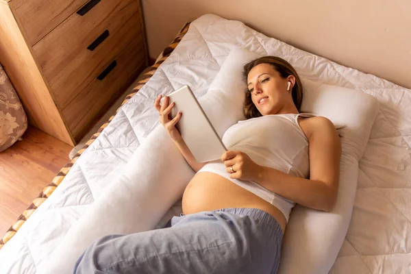 Pregnancy app tablet. Mobile pregnancy online maternity application. Pregnant mother using digital tablet. Concept of pregnancy, maternity, expectation for baby birth