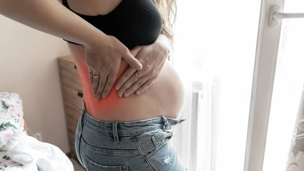 Pregnancy back pain. Beautiful pregnant woman suffer from back pain, backache. Ache spine therapy, healthcare concept