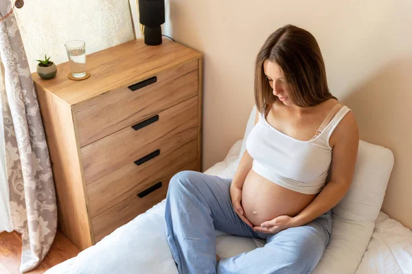 Pregnancy yoga meditation. Health yoga home sport. Beautiful pregnant woman meditating while sitting in lotus position. Concept maternity, pregnancy, childbirth