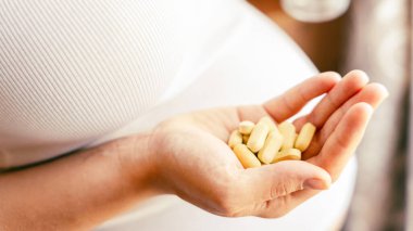 İlaçlar vitamin hapı. Elinde vitamin hapı tutan mutlu hamile kadın. Terapi, sağlık, annelik kavramı.