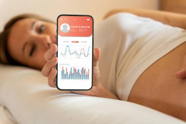 Hamilelik akıllı telefon uygulaması. Elinde akıllı telefon tutan hamile bir kadın. Taşınabilir hamilelik çevrimiçi annelik başvurusu. Gebelik, gebelik, doğum