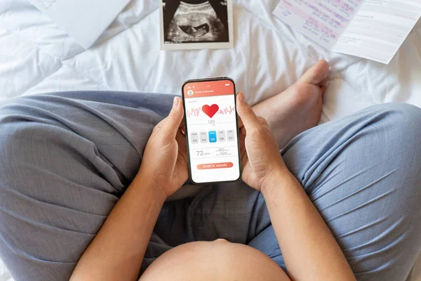 Pregnancy health app. Pregnant woman holding smartphone. Mobile pregnancy online maternity application. Concept of pregnancy, maternity, expectation for baby birth