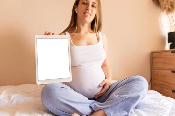 Pregnancy digital tablet screen. Pregnant woman holding smart tablet mock up. Mobile pregnancy online maternity application. Concept of pregnancy, maternity, expectation for baby birth