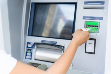 ATM 'den nakit para. Amerikan banknotlarını elinde tutuyor. Kadın, 100 dolar çekmiş. Amerikan doları, banka kartı.