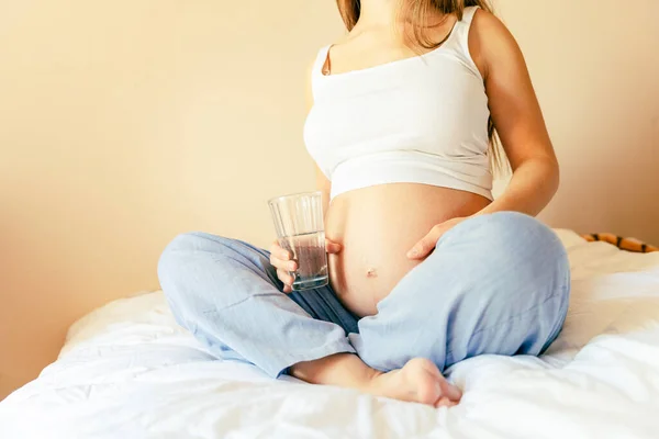 妊娠中の飲酒女性 妊娠中のきれいな飲料水 幸せな妊婦の水のガラスを保持する 産前産後期待 — ストック写真