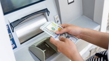 ATM kartı, nakit. Amerikan banknotlarını elinde tutuyor. Kadın, 100 dolar çekmiş. Banka kredi kartı para geçmişi