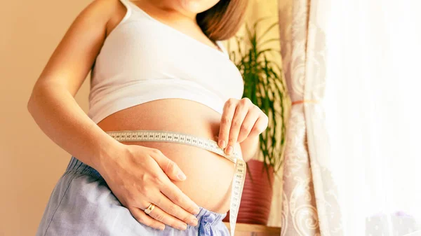 妊娠中の女性を測定します 腹を測定するテープで幸せな美しい妊婦 出産への期待 — ストック写真