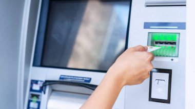 ATM ekranı. Amerikan banknotlarını elinde tutuyor. Kadın, 100 dolar çekmiş. Para yığını, banka kartı.